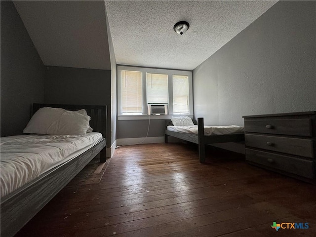 906 N Penelope St, Belton, TX 76513 - bedroom featuring wood-type flooring, a textured ceiling, a textured wall, vaulted ceiling, and baseboards