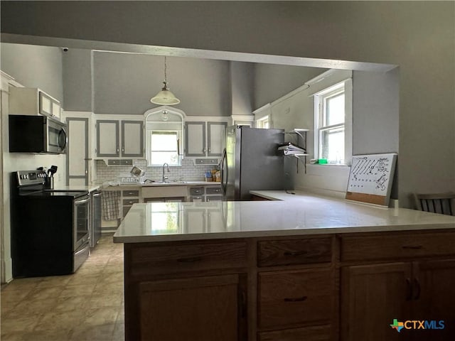 906 N Penelope St, Belton, TX 76513 - kitchen featuring stainless steel appliances, a sink, a peninsula, decorative backsplash, and light countertops