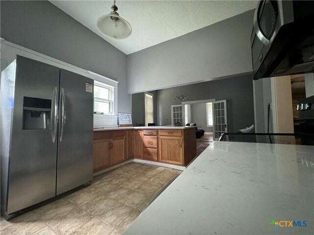 906 N Penelope St, Belton, TX 76513 - kitchen featuring stainless steel fridge with ice dispenser, light countertops, lofted ceiling, brown cabinetry, and a peninsula