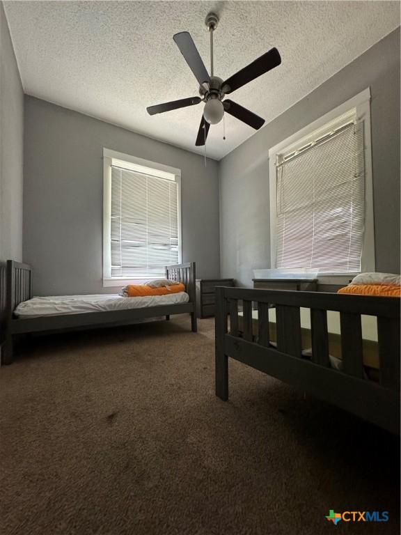 906 N Penelope St, Belton, TX 76513 - unfurnished bedroom with carpet flooring, a textured ceiling, and ceiling fan