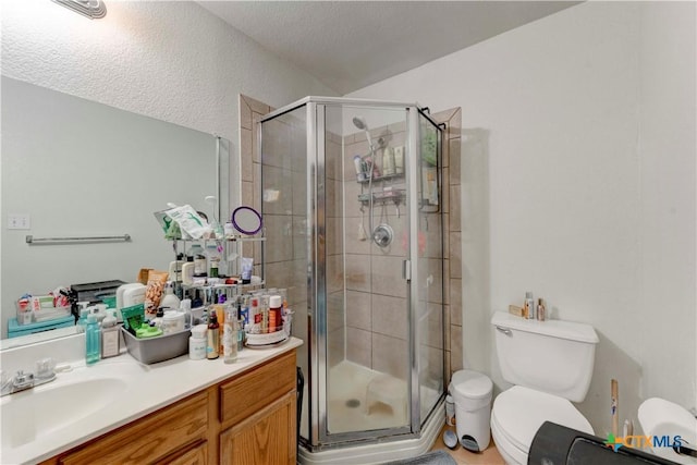 bathroom featuring a textured ceiling, vanity, toilet, and an enclosed shower