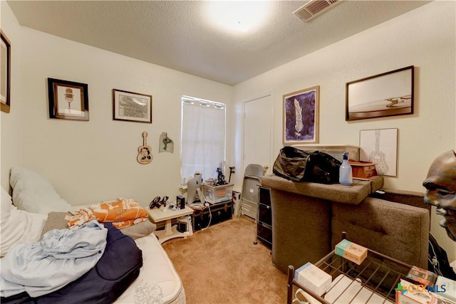 carpeted home office featuring a textured ceiling