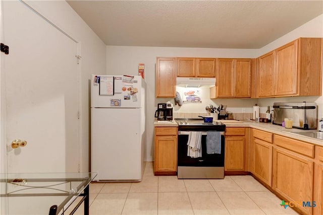 kitchen with electric stove, sink, white fridge, and light tile patterned flooring