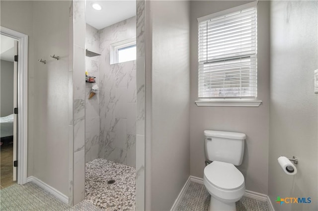 211 Amberglow Ct, Victoria, TX 77904 - bathroom featuring a marble finish shower, toilet, and baseboards