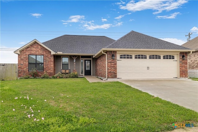 211 Amberglow Ct, Victoria, TX 77904 - view of front of home with a garage, concrete driveway, brick siding, and roof with shingles
