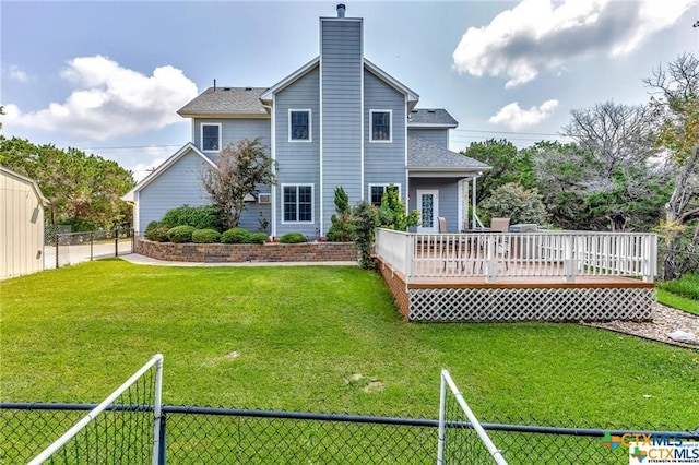 rear view of property featuring a wooden deck and a lawn