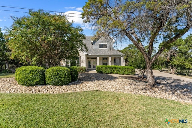 cape cod home featuring a front lawn