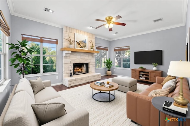 16047 Charlya Dr, Temple, TX 76502 - living room with ceiling fan, baseboards, wood finished floors, a stone fireplace, and crown molding
