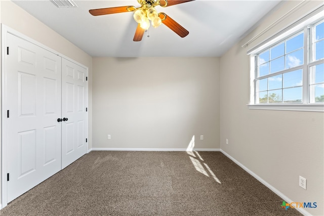 unfurnished bedroom with ceiling fan, a closet, and carpet floors