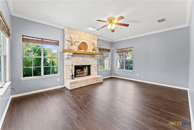 16047 Charlya Dr, Temple, TX 76502 - unfurnished living room featuring a ceiling fan, baseboards, dark wood-style floors, ornamental molding, and a stone fireplace