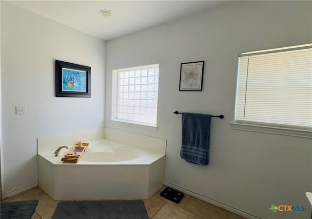 bathroom with tile patterned floors and a washtub