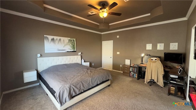 bedroom with carpet flooring, ceiling fan, ornamental molding, and a tray ceiling