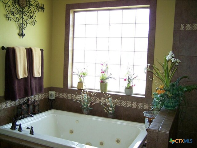 101 Laurel Oak Cir, Cuero, TX 77954 - bathroom featuring a jetted tub and plenty of natural light