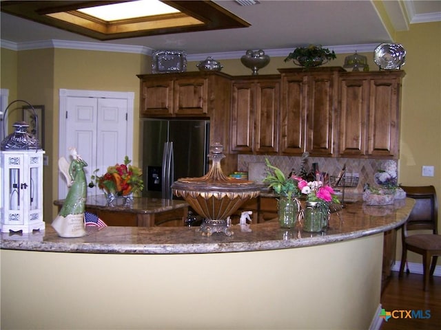 101 Laurel Oak Cir, Cuero, TX 77954 - kitchen featuring fridge with ice dispenser, light stone countertops, ornamental molding, decorative backsplash, and dark wood-style floors