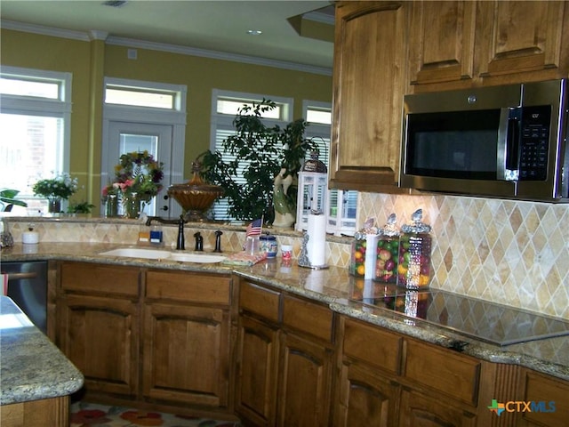 101 Laurel Oak Cir, Cuero, TX 77954 - kitchen with appliances with stainless steel finishes, a sink, backsplash, light stone countertops, and crown molding