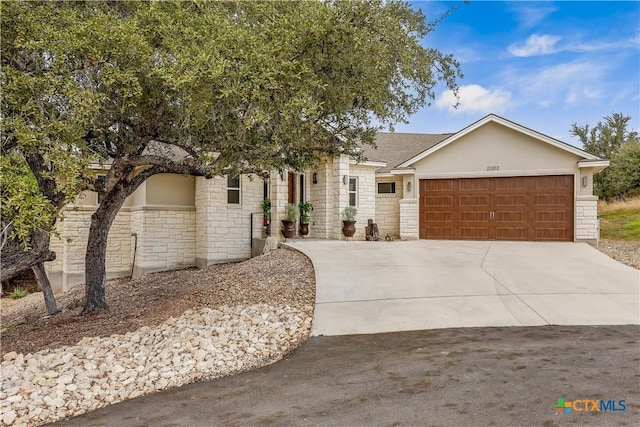 view of front facade featuring stucco siding, stone siding, concrete driveway, and an attached garage