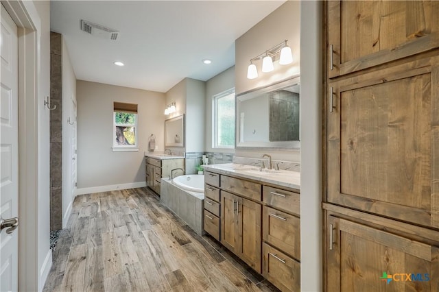 bathroom featuring a tub, hardwood / wood-style floors, and vanity