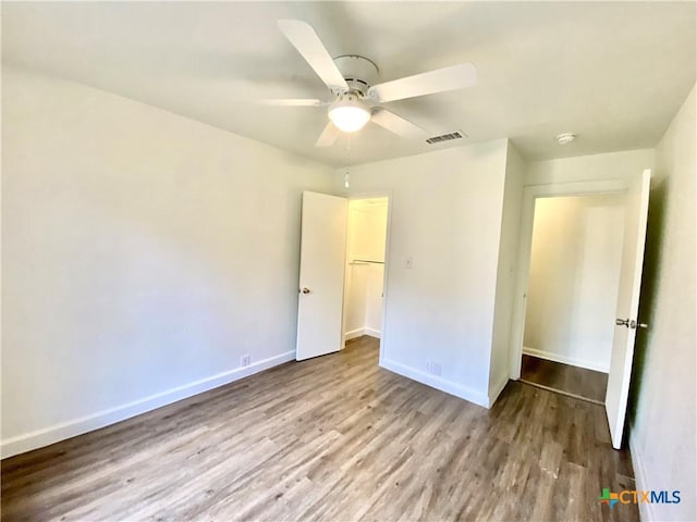 unfurnished bedroom featuring ceiling fan, light wood-type flooring, and a closet