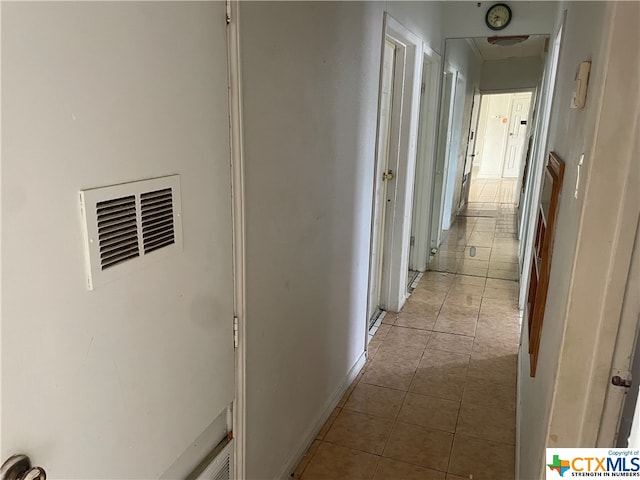 hall with light tile patterned floors