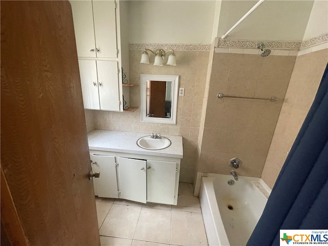 bathroom featuring tile walls, tile patterned flooring, shower / bath combination, and vanity