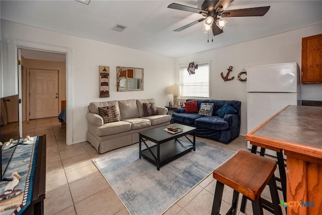 living room with ceiling fan and light tile patterned flooring