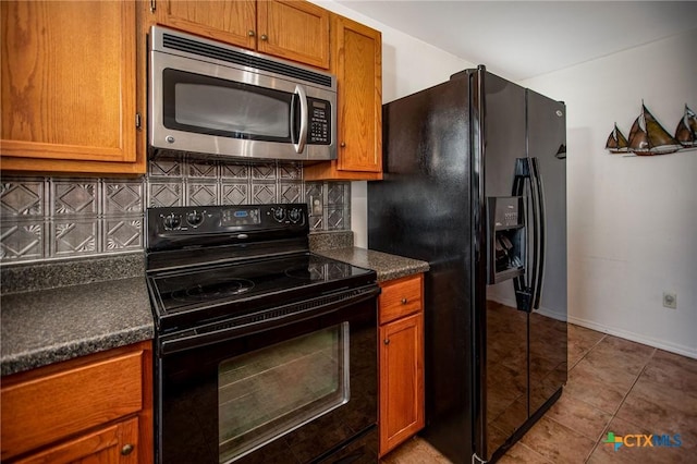 kitchen featuring light tile patterned floors, decorative backsplash, and black appliances