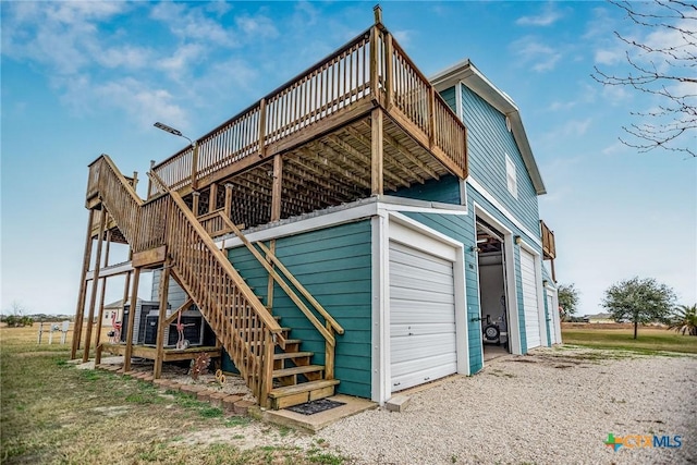 back of property featuring a garage and a wooden deck