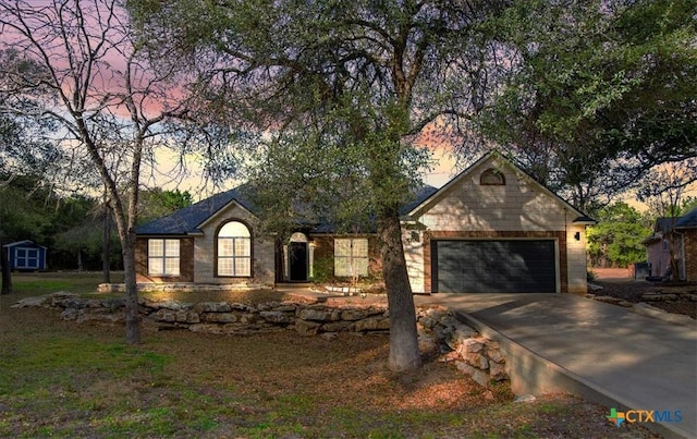 ranch-style home with a storage shed, driveway, an attached garage, and an outdoor structure