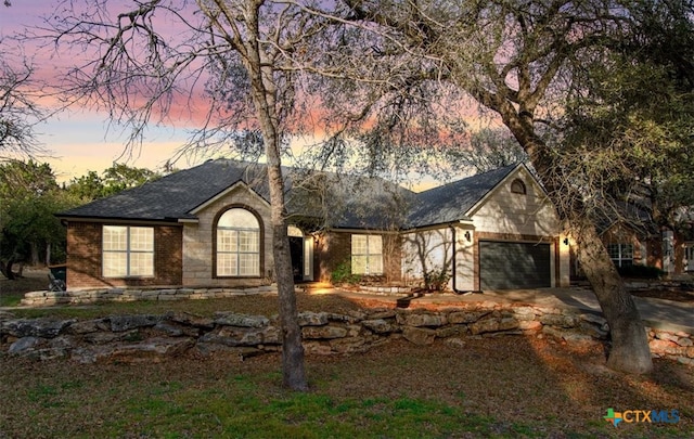 single story home with a garage, brick siding, and driveway