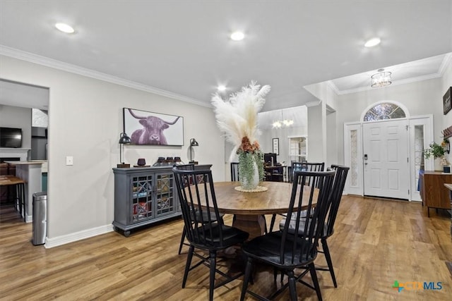 dining room featuring a chandelier, ornamental molding, wood finished floors, and baseboards