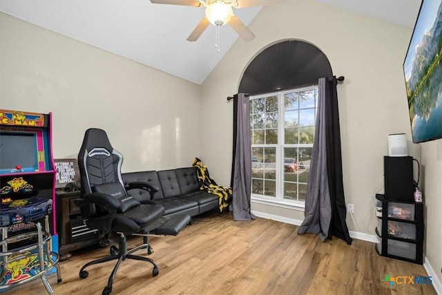 office space with a ceiling fan, vaulted ceiling, baseboards, and wood finished floors