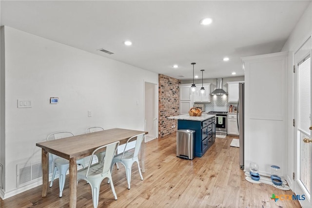 205 Timberline Rd, Temple, TX 76502 - kitchen with stainless steel range oven, wall chimney exhaust hood, blue cabinets, decorative backsplash, and light wood-type flooring