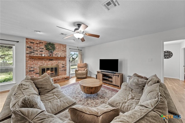 205 Timberline Rd, Temple, TX 76502 - living room with light wood finished floors, a ceiling fan, a brick fireplace, and baseboards