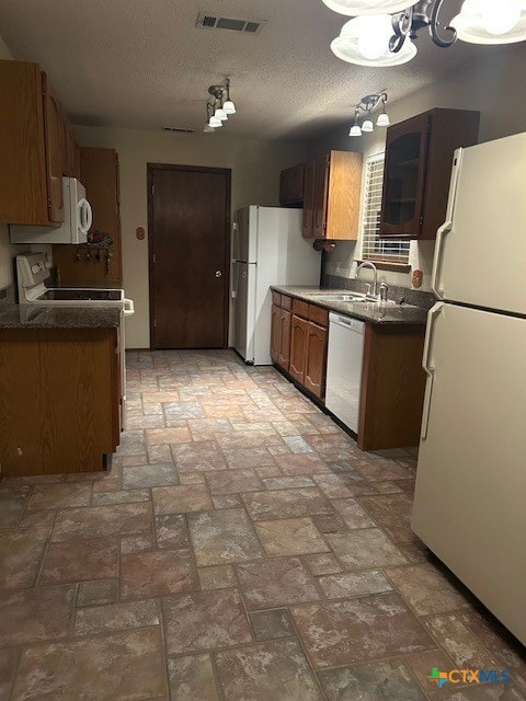 kitchen with white appliances, sink, and a textured ceiling