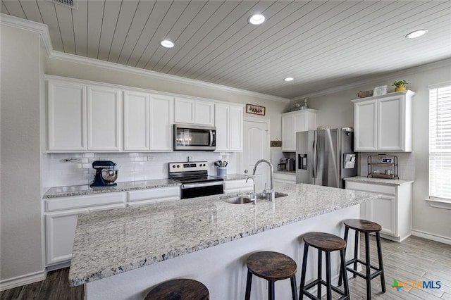 2844 Klein Way, New Braunfels, TX 78130 - kitchen with stainless steel appliances, a sink, a breakfast bar area, white cabinetry, and recessed lighting