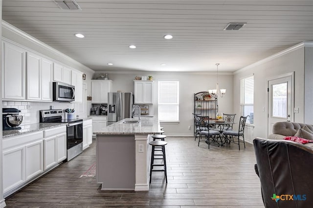 2844 Klein Way, New Braunfels, TX 78130 - kitchen featuring stainless steel appliances, ornamental molding, a breakfast bar, a chandelier, and white cabinetry