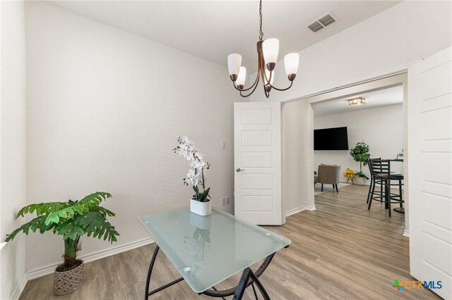 14902 Ardilla, San Antonio, TX 78217 - dining room featuring light wood-style floors, a chandelier, and baseboards