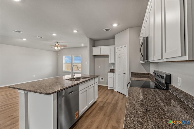 702 Stonevalley Rd, Temple, TX 76502 - kitchen featuring appliances with stainless steel finishes, white cabinetry, a ceiling fan, light wood-style floors, and dark stone countertops
