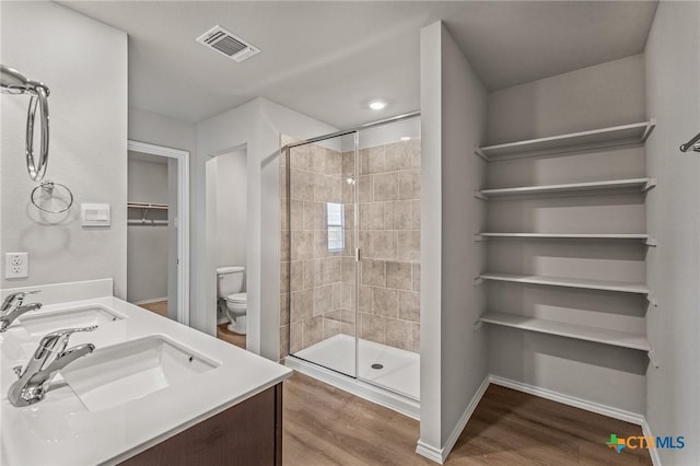 702 Stonevalley Rd, Temple, TX 76502 - bathroom with wood finished floors, a shower stall, double vanity, and a walk in closet