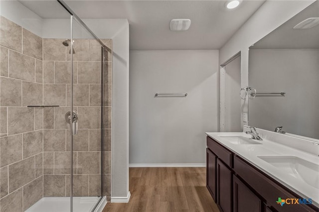 702 Stonevalley Rd, Temple, TX 76502 - bathroom with a tile shower, double vanity, and wood finished floors