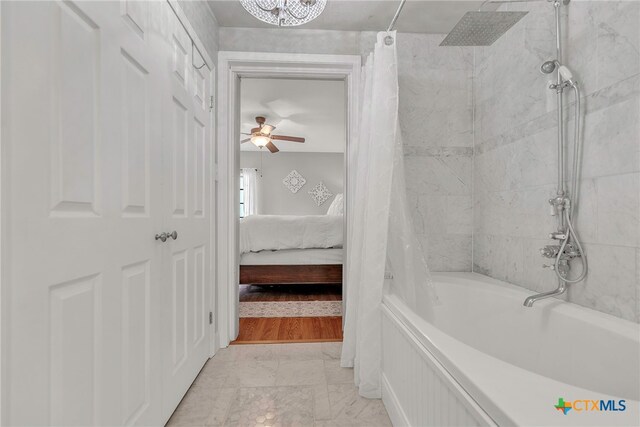 bathroom featuring ceiling fan and shower / tub combo with curtain