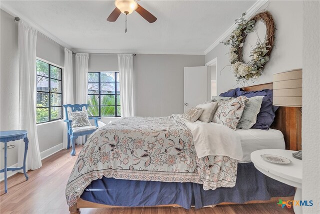 bedroom with hardwood / wood-style floors, ceiling fan, and ornamental molding