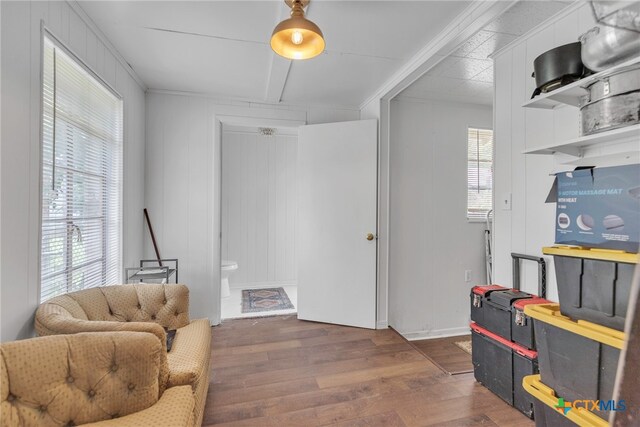 living area featuring dark wood-type flooring and crown molding