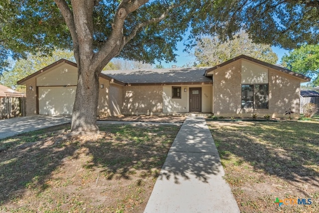 ranch-style home with a garage and a front lawn