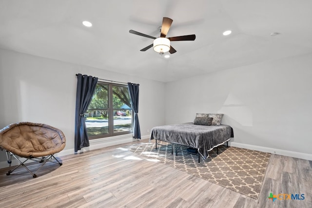 bedroom featuring ceiling fan, lofted ceiling, and light hardwood / wood-style flooring