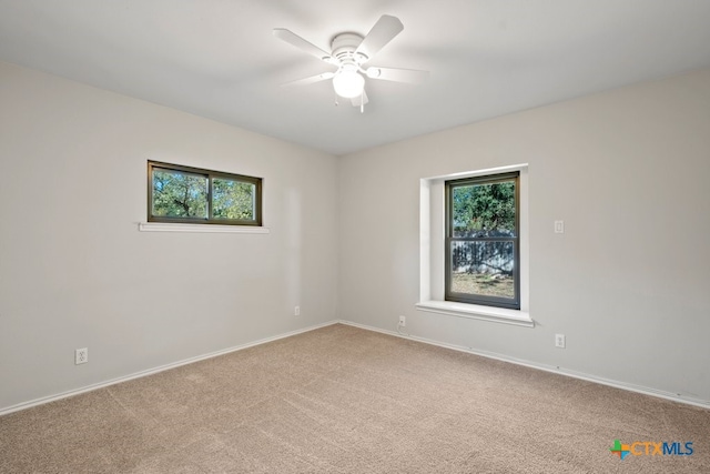 empty room featuring carpet floors, a wealth of natural light, and ceiling fan