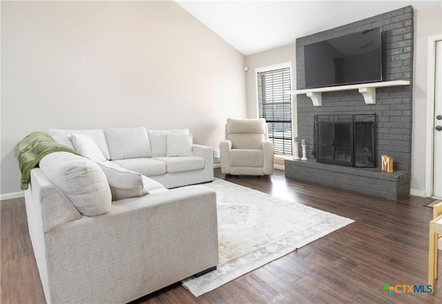 418 Taos Dr, Victoria, TX 77904 - living room featuring vaulted ceiling, a brick fireplace, wood finished floors, and baseboards