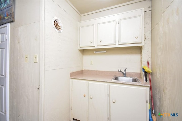 1588 W Bayshore Dr, Palacios, TX 77465 - kitchen with a sink, light countertops, and white cabinetry