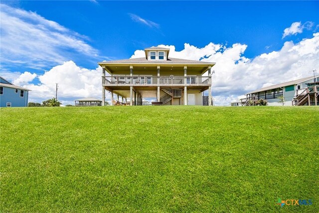 1588 W Bayshore Dr, Palacios, TX 77465 - back of house featuring stairs, a lawn, a garage, and a deck