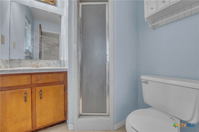 bathroom with a shower with door, vanity, and toilet